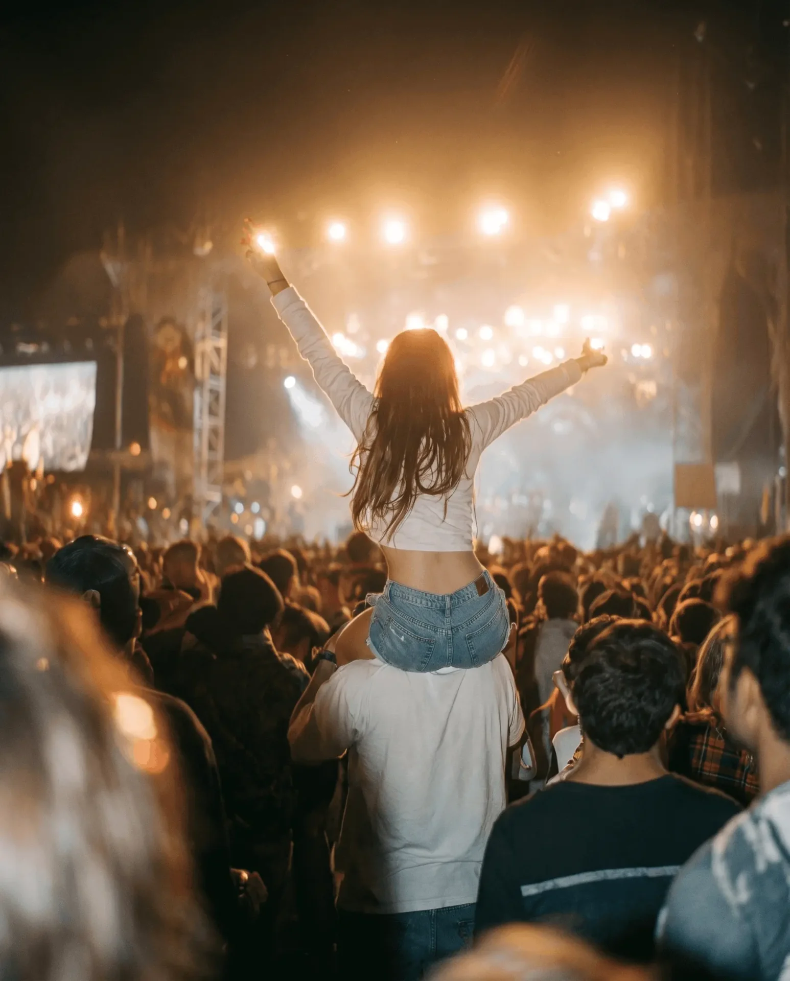 A crowd with hands raised at a live concert